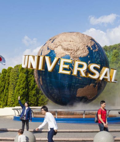 Osaka, Japan - October 27, 2014: View of tourists and Universal Globe outside the Universal Studios Theme Park in Osaka, Japan. The theme park has many attractions based on the film industry.